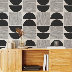 Könnte beinhalten: Geometrische Tapete mit einem sich wiederholenden Muster aus schwarzen Halbkreisen und vertikalen Linien auf beigem Hintergrund. Das Design ist modern und minimalistisch. Ein Holzschrank mit dekorativen Gegenständen befindet sich im Vordergrund.