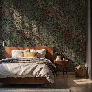 Puede incluir: Dormitorio con cama de madera, ropa de cama blanca y almohada amarilla. El cabecero está contra una pared cubierta con un papel pintado oscuro con hojas. También se ven una mesita de noche de madera y una cesta de mimbre.