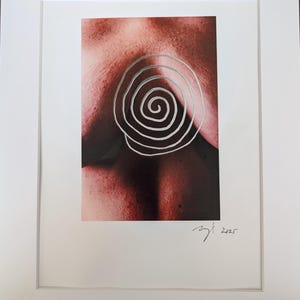 May include: Framed art print showing a close-up of skin tones with a silver spiral design. The artwork is signed and dated 2025 in the lower right corner. The print is set in a white mount.