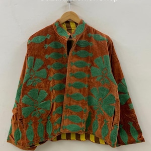 May include: A brown velvet jacket with green floral embroidery. The jacket has a mandarin collar and a striped yellow and brown lining. The text "SuzaniFashionShop" is visible at the top.