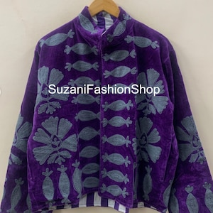 May include: A purple velvet jacket with gray embroidered floral and abstract designs. The jacket has a high collar and a button-up front. The text "SuzaniFashionShop" is printed on the front.