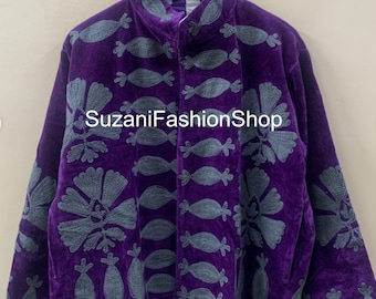 Puede incluir: Una chaqueta de terciopelo morado con diseños florales y abstractos bordados en gris. La chaqueta tiene un cuello alto y una botonadura frontal. El texto "SuzaniFashionShop" está impreso en la parte delantera.