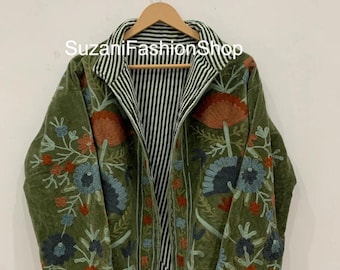 Puede incluir: Chaqueta bordada verde oliva con diseños florales en rojo, azul y naranja. La chaqueta tiene un forro a rayas y el texto "SuzaniFashionShop" es visible. La chaqueta está colgada en una percha de madera.