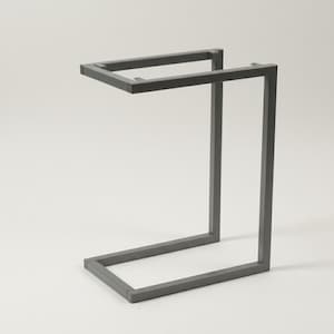 Pode incluir: Uma mesa lateral moderna de metal cinza com um design exclusivo em forma de C. A mesa apresenta um tampo e uma base retangulares, conectados por um suporte vertical. O design minimalista é adequado para vários estilos de interiores.