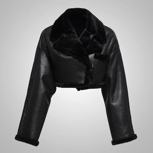 May include: A cropped black faux leather jacket with a plush black faux fur collar and trim. The jacket has long sleeves and a classic aviator style, perfect for adding a touch of edgy sophistication to any outfit.