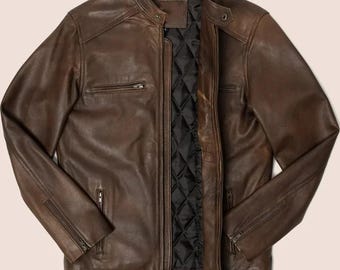 Puede incluir: Chaqueta de cuero marrón con cremallera frontal, dos bolsillos en el pecho con cremallera y dos bolsillos para las manos con cremallera. La chaqueta tiene un forro negro acolchado y un cuello alzado. Las mangas tienen puños con cremallera.