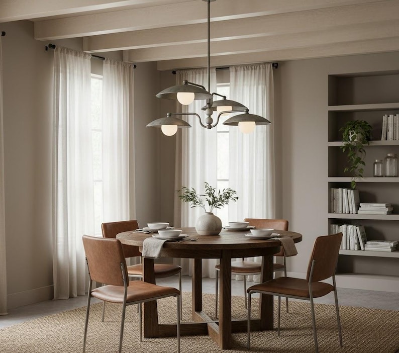 May include: A dining room set with a round wooden table, four brown leather chairs, and a metal chandelier with five lights. The room has sheer white curtains and a neutral color scheme.