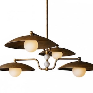 May include: A bronze-toned, multi-light chandelier with four downward-facing, saucer-shaped shades. Each shade has a spherical, frosted glass bulb. The fixture has a central stem and decorative marble accents.