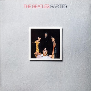 May include: Album cover for The Beatles' "Rarities." The album art features a square image of the band members in a white border, set against a textured gray background. The band's name and album title are in red and black text.
