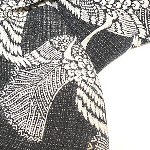 May include: Black fabric with a white crane pattern. The fabric is textured and has a subtle sheen. The cranes are stylized and have intricate details.