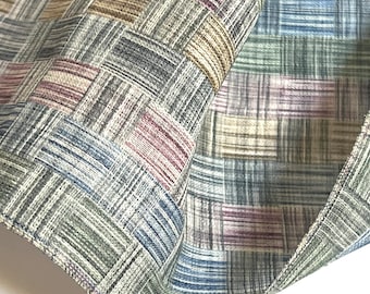 May include: A close-up of a woven fabric with a checkered pattern in shades of gray, blue, pink, and beige.