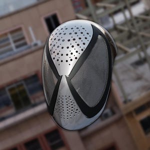 May include: A metallic silver mask featuring a smooth, rounded surface with a series of small, circular perforations across the forehead and chin areas. The design includes two large, black-bordered eye sections covered with a fine silver mesh screen.