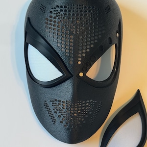 Puede incluir: Una m&aacute;scara negra texturizada con cubiertas oculares de malla blanca y una pieza ocular separada. La m&aacute;scara tiene un dise&ntilde;o perforado en las secciones superior e inferior. Probablemente para cosplay o disfraces.