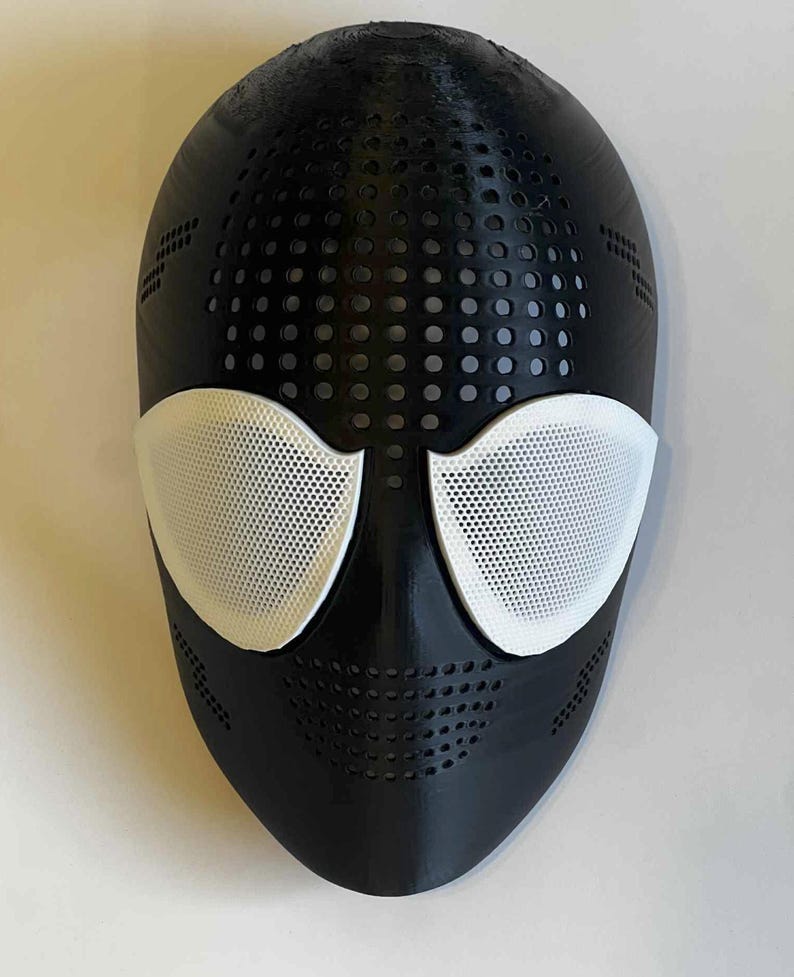 Puede incluir: Una m&aacute;scara negra con cubiertas oculares de malla blanca. La m&aacute;scara tiene una serie de peque&ntilde;os orificios de ventilaci&oacute;n circulares y rectangulares. La m&aacute;scara est&aacute; dise&ntilde;ada para cubrir la cara.