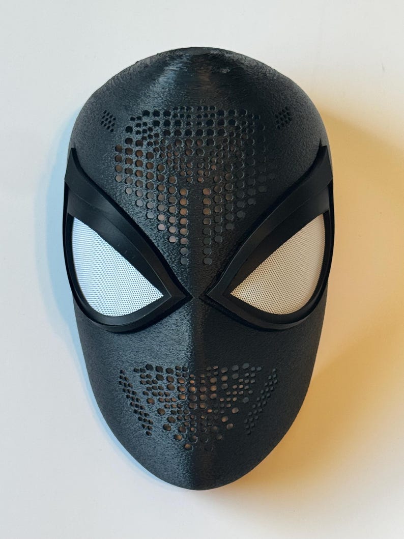 Puede incluir: Una m&aacute;scara negra con cubiertas oculares de malla blanca y una superficie texturizada. La m&aacute;scara tiene un dise&ntilde;o de peque&ntilde;os agujeros en la frente y la boca. Accesorio de disfraz de superh&eacute;roe.