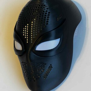 Puede incluir: Una m&aacute;scara negra con cubiertas oculares de malla blanca. La m&aacute;scara tiene una serie de peque&ntilde;os agujeros espaciados uniformemente en la parte superior y los lados. La m&aacute;scara est&aacute; dise&ntilde;ada para cubrir la cara y tiene un acabado liso y mate.