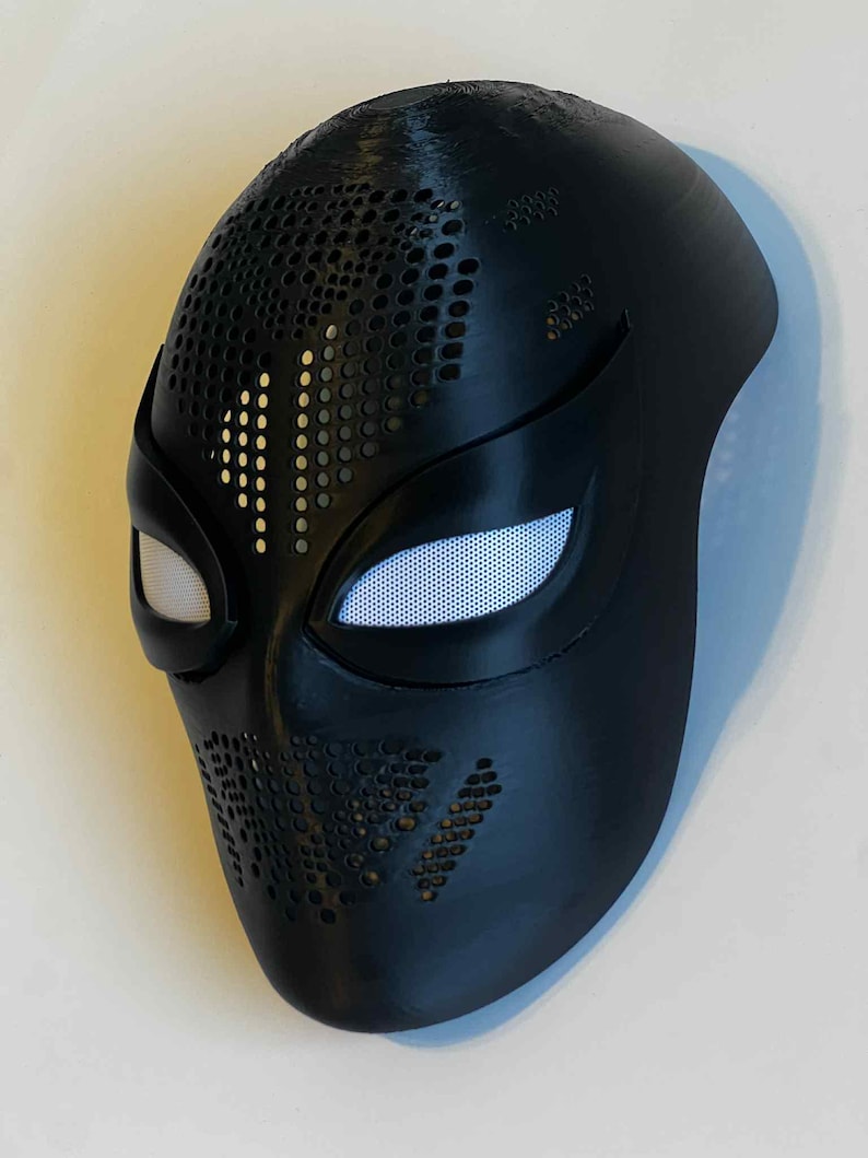 Puede incluir: Una m&aacute;scara negra con cubiertas oculares de malla blanca. La m&aacute;scara tiene una serie de peque&ntilde;os agujeros espaciados uniformemente en la parte superior y los lados. La m&aacute;scara est&aacute; dise&ntilde;ada para cubrir la cara y tiene un acabado liso y mate.