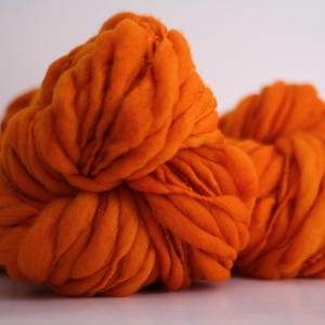 May include: A large ball of orange yarn, perfect for knitting or crocheting.