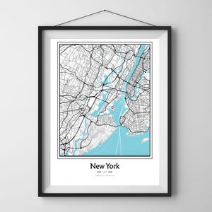 May include: Framed black and white map of New York City with a light blue water colour. The city name is printed in a clean font at the bottom of the map.