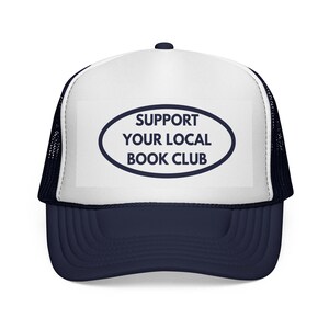 Peut inclure: Casquette de camionneur bleu marine et blanche. Le texte "SUPPORT YOUR LOCAL BOOK CLUB" est inscrit dans un ovale bleu marine sur le panneau avant blanc. Visière et dos en filet bleu marine.