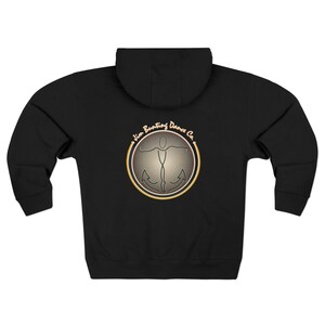 Può includere: Felpa con cappuccio nera con zip e cappuccio. La parte posteriore presenta un logo circolare con una silhouette di ballerino e il testo "Jim Bunting Dance Co." in un design oro e grigio. La felpa ha una zip integrale e maniche lunghe.