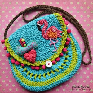 Könnte beinhalten: Türkisfarbene Häkeltasche mit braunem Riemen. Sie hat eine Applikation eines rosa Flamingos, ein rotes Herz und das Wort "Summer" auf einer blauen Filzform gestickt. Verziert mit rosa Pompons und grünen Verzierungen.