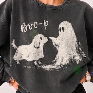 May include: A charcoal grey crewneck sweatshirt featuring a distressed white graphic of a ghost and a dog wearing a ghost costume. The text "BOO-p" is printed in white above the figures. The garment has a washed, vintage-style texture.