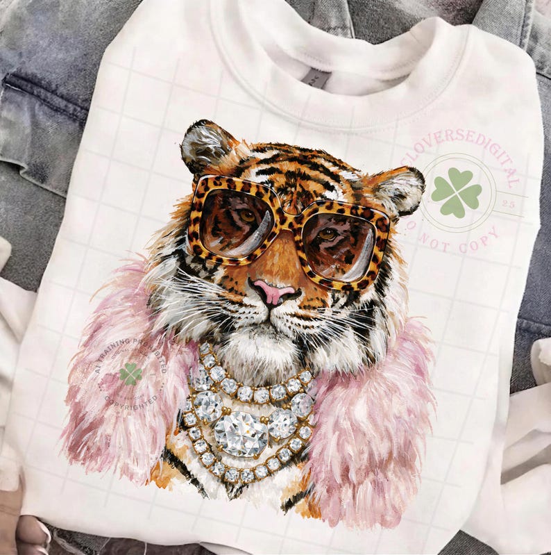 May include: White sweatshirt featuring a tiger wearing leopard print sunglasses, a pink feather boa, and a diamond necklace. The tiger illustration has a detailed design. The sweatshirt has the text "LOVERSEDIGITAL" and "NOT COPY".