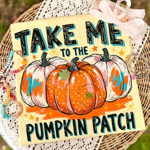 May include: A square sign with a light yellow grid background featuring the text "TAKE ME TO THE PUMPKIN PATCH" in black and blue. The design includes three pumpkins, one orange with white dots and two pale pink, accented by small orange stars.