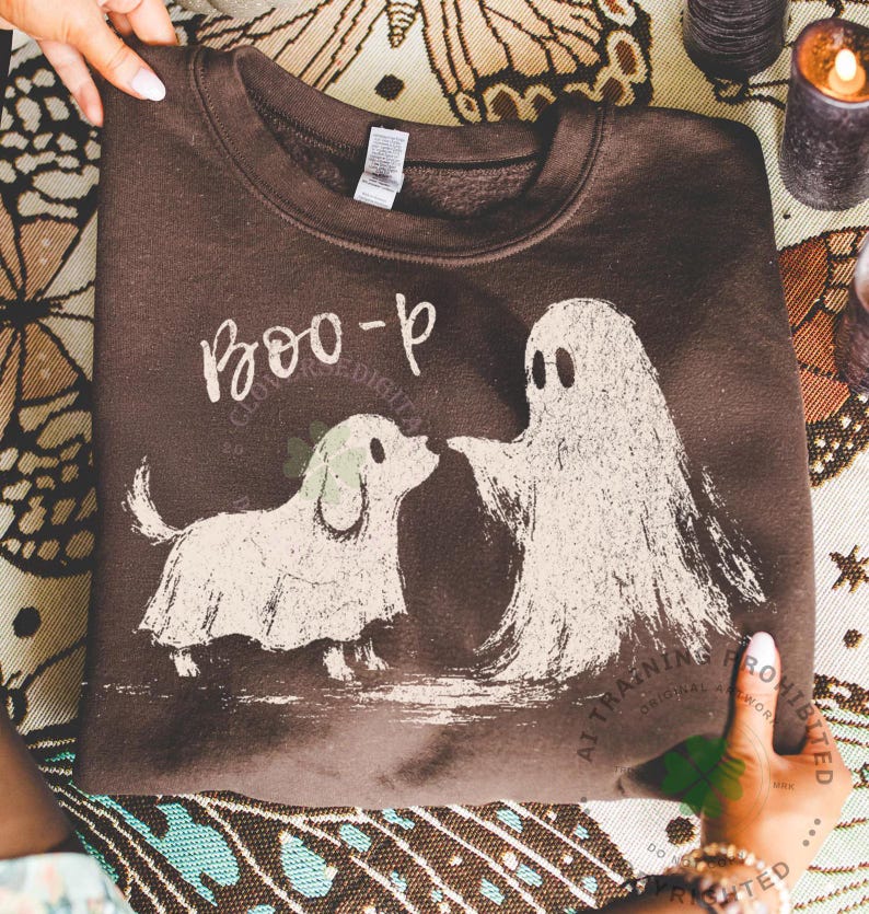 May include: A dark brown crewneck sweatshirt featuring a distressed white graphic print of a small dog wearing a ghost costume standing next to a ghost. The text "BOO-p" is printed in a white, hand-lettered style above the two figures.