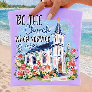May include: A lavender-colored rectangular item with the text "BE THE Church WHEN SERVICE is OVER" and a watercolor painting of a church surrounded by flowers. The church has a white exterior, a blue roof, and a gold cross.