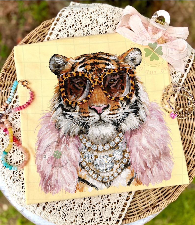 May include: A yellow canvas print featuring a tiger wearing leopard print sunglasses, a pink feather boa, and a diamond necklace. The tiger's fur is orange and black. A pink bow and jewelry are in the background.