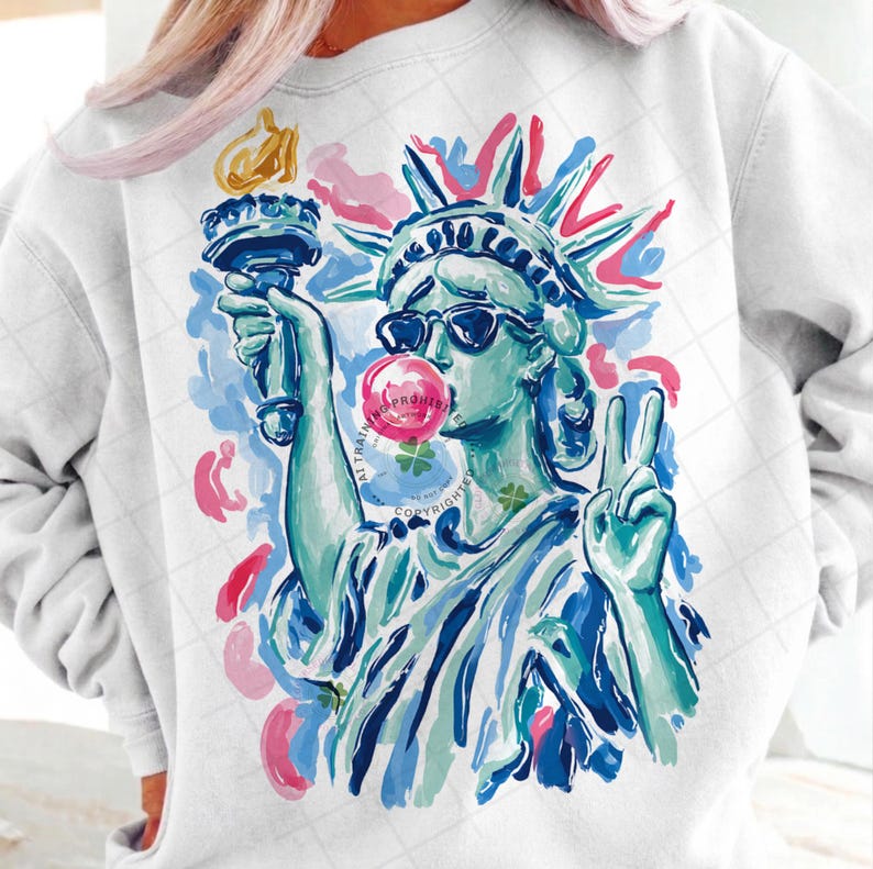 May include: White sweatshirt featuring a colorful graphic of the Statue of Liberty wearing sunglasses and blowing a bubblegum bubble. The Statue of Liberty is holding a torch and making a peace sign.