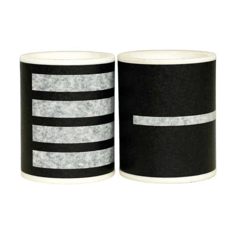 May include: Two black and white striped ceramic mugs. The mug on the left has four white stripes, and the mug on the right has one white stripe.