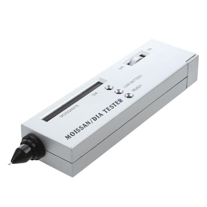 May include: A silver Moissan/DIA tester with a black tip. The device has a digital display and buttons labeled "DIA", "LOW BATTERY", and "READY". A switch is labeled "OFF" and "ON".