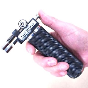 May include: A black and silver GB-2001 piezo gas burner with a textured handle. The burner has a dial and a nozzle. The text "GB-2001 piezo gas burner" is printed on the side.