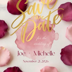Op de afbeelding: Een Save the Date trouwkaart met gouden scripttekst, een centrale roze aquarelvlek en verspreide rozenblaadjes in tinten diep bordeaux en zacht blushroze. De tekst luidt Joe + Michelle, 21 november 2026, Raleigh, North Carolina.