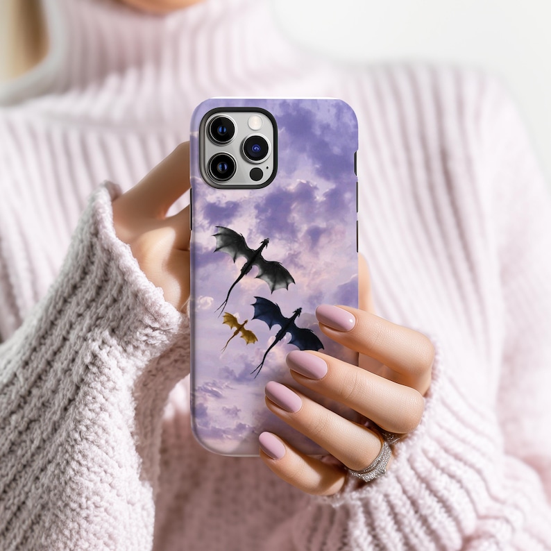 May include: A phone case featuring a purple sky with three dragons in flight. The dragons are black and gold, with a detailed design. The case has a glossy finish and is designed for a smartphone.