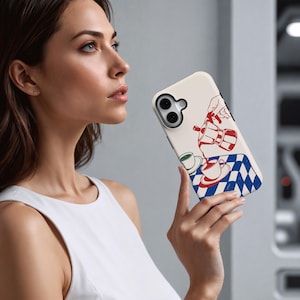 May include: A cream phone case with a red and white coffee pot illustration pouring into a cup, set against a blue and white chequered tablecloth. The case has a black border and a camera cutout.