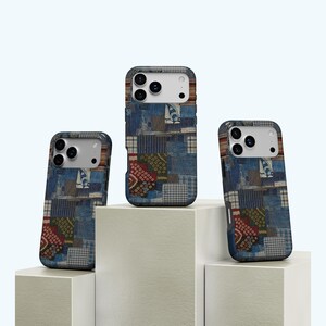 May include: Three phone cases with a patchwork design. The cases feature a mix of blue denim-like fabrics with various patterns, including squares, circles, and geometric shapes. The cases are displayed on white platforms.