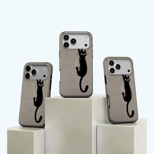 May include: Three mobile phone cases with a tan fabric texture and a black cat design. The cat is hanging from the top of the case. The cases are displayed on white geometric blocks.