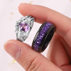 May include: A white ceramic mug with a black handle and the text "But First, Coffee" in a bold, black font. The mug is set against a blurred background, suggesting a cozy setting.