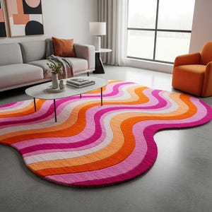 May include: A vibrant area rug featuring a wavy pattern in pink, orange, and white. The rug is positioned on a grey floor in a living room. The rug's distinctive shape and bright colours bring a contemporary feel to the space.