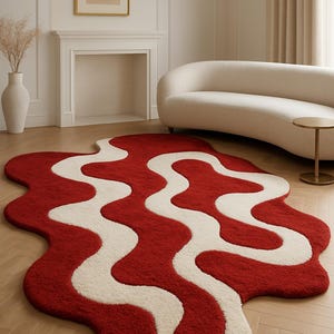 Puede incluir: Una alfombra roja y blanca con un patrón ondulado. La alfombra presenta un diseño audaz con un fondo rojo intenso y un patrón blanco fluido. Se coloca sobre un suelo de madera clara, agregando un toque de color a la habitación.