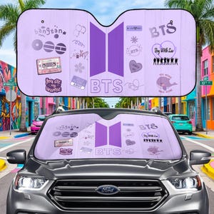 May include: A lavender car sunshade featuring the BTS logo and various related graphics. The design includes the text "bangtan", "You are my Universe", "ARMY", and "Boy With Luv". The sunshade is installed in a Ford SUV.