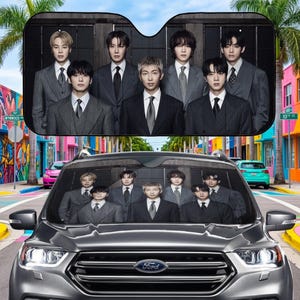 May include: A black car sunshade featuring a group of eight people in suits. The sunshade is placed in a gray Ford SUV, with a colorful street scene in the background.