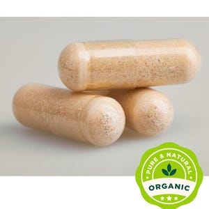 May include: Close-up of three beige capsules, stacked. The capsules are filled with a light brown powder. A green and white circular label with the words "Pure & Natural" and "Organic" is in the lower right corner.