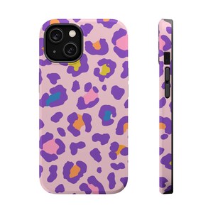 Könnte beinhalten: Eine Handyhülle mit hellrosa Hintergrund und einem sich wiederholenden Leopardenmuster in den Farben Violett, Orange, Gelb und Blau. Das Design bedeckt die Rückseite und die Seitenkante und zeigt den Kameraausschnitt sowie die Seitentasten.