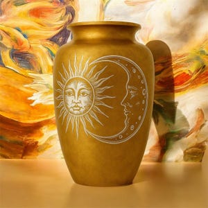 May include: A gold-colored vase with a wide mouth and a rounded body. The vase features a white illustration of the sun and moon. The sun has a face, and the moon has a profile. The background is a colorful abstract design.