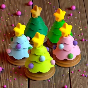 May include: A collection of five colorful Christmas tree decorations. Each tree is a different color, including green, blue, pink, and lime green, and is topped with a yellow star. The trees are decorated with small, round, colorful ornaments.